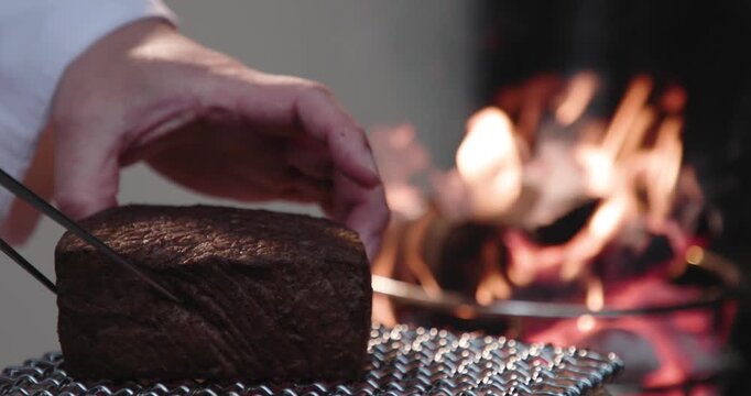 炭焼き・網焼きで牛肉のブロックステーキを炭火の直火でを焼く　バーベキュー料理・肉料理・炎　アウトドア