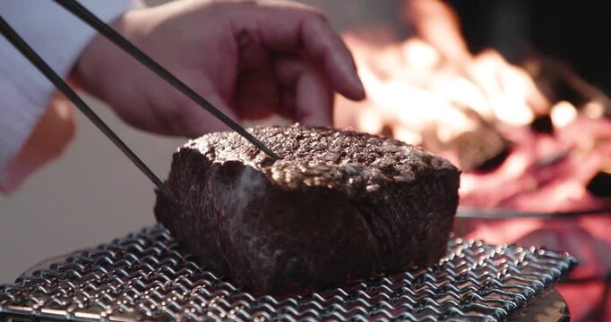 炭焼き・網焼きで牛肉のブロックステーキを炭火の直火でを焼く　バーベキュー料理・肉料理・炎　アウトドア