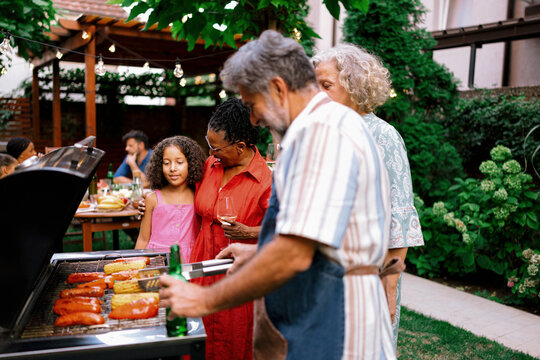 Multigenerational Family Enjoying Time Together by Backyard Grill