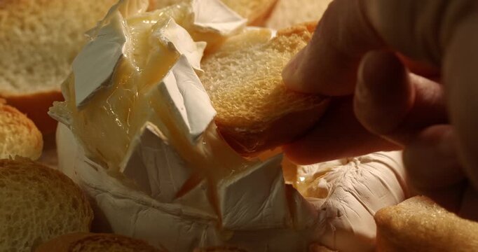 Crouton dipped into baked camembert, close‑up footage.