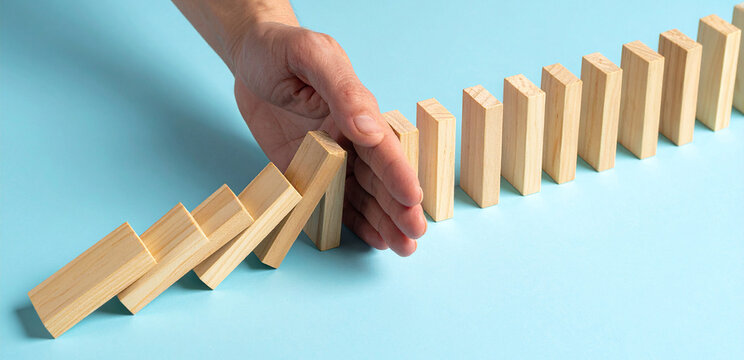 Hand verhindert, das weitere Dominosteine fallen