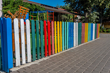 Obraz premium A colorful wooden fence in front of a building.