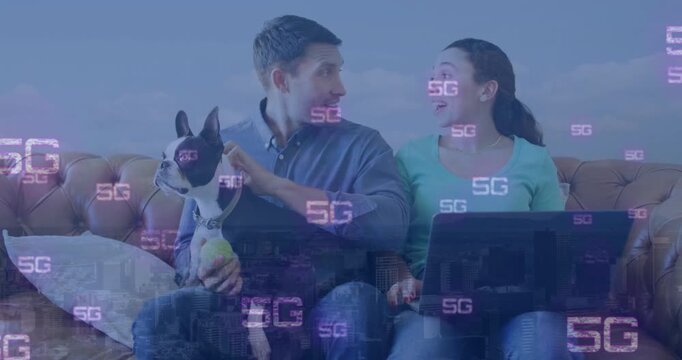 Animation of 5g text repeated over happy caucasian couple with dog using laptop at home