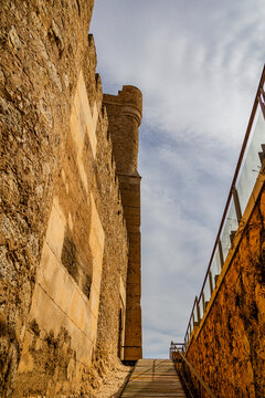 A stone staircase leads up between the ancient walls of a historic La Atalaya Castle, Villena, Spain