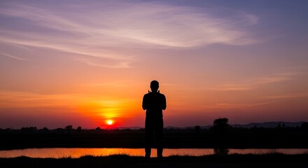 Obraz premium Silhouette of a man contemplating life at sunset.