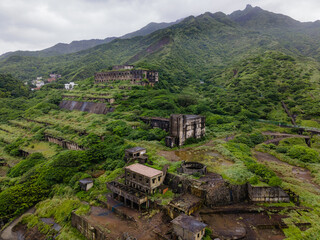 Aerial view of the abandoned 13 Levels gold and copper smelters near Jiufen, Taiwan, showing overgrown terraces and industrial ruins reclaimed by lush vegetation