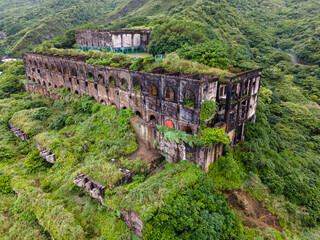 Aerial close-up of the upper-level remains of the 13 Levels gold and copper smelters near Jiufen, Taiwan, highlighting decaying concrete structures, geometric forms, and dramatic industrial heritage t