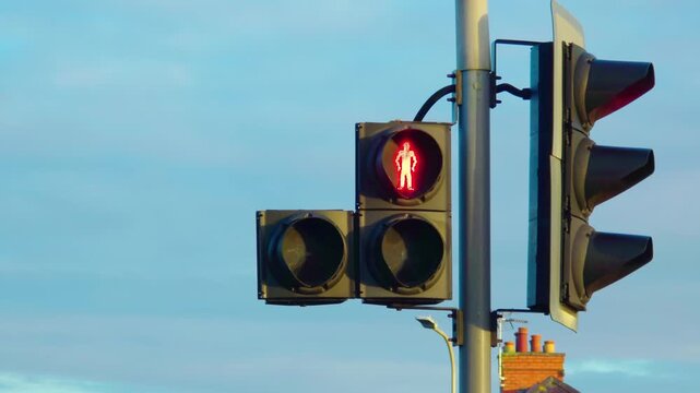 Red pedestrian traffic light changing toward green while urban signal system operating. Street crossing waiting phase ending and movement preparing to start. Road safety concept reflecting transition