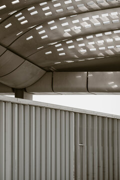 Industrial modern architecture structure with minimal metal ceiling pattern where light and shadow create abstract geometry for sleek interior design