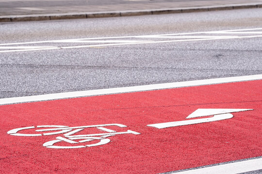 Red road bicycle lane for urban cycling commute showing sustainable transport mobility and safety markings for daily travel infrastructure