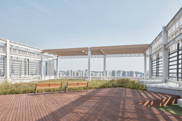 Obraz premium Modern rooftop terrace with wooden deck and city skyline view