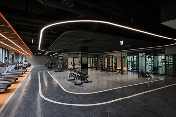 Spacious modern gym floor with strength training equipment