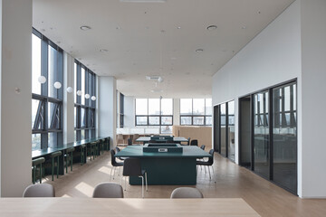 Minimalist public library interior with rows of green study desks