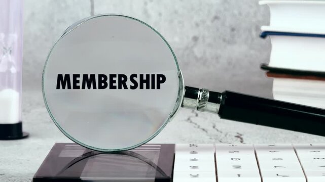 Magnifying glass highlights membership on a desk. Emphasizes belonging, community in evolving corporate culture