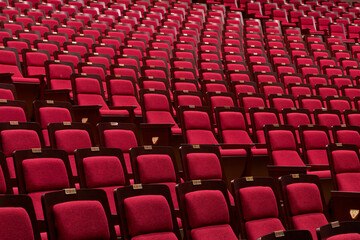Naklejka premium Close up of red plush seats in rows at a performance venue