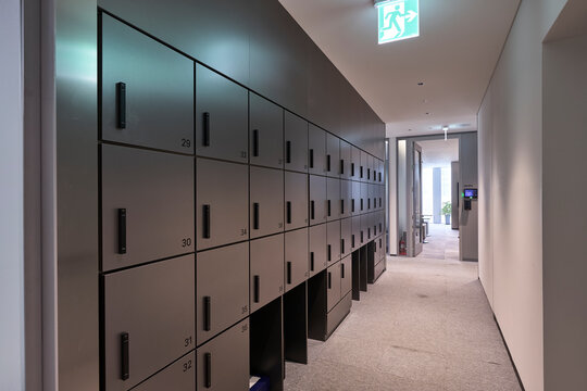Modern office locker room corridor with dark metal cabinets