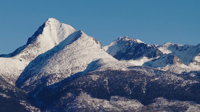 Detailed winter view of the iconic Kriv&aacute;ň peak in the High Tatras, Slovakia. Snow covered mountain slopes and sharp ridgelines under clear blue sky, powerful alpine landscape and national symbol.