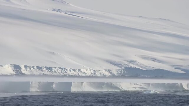 Massive Antarctic Ice Wall Rising Above Calm Polar Water