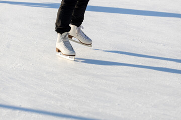 A woman in the ice stadium. A woman's legs in skates