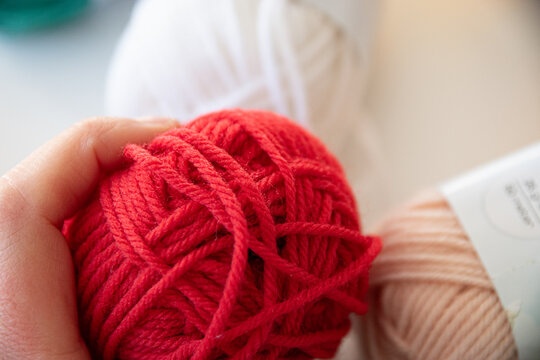 Pelote de laine rouge s&eacute;lectionn&eacute;e par une main