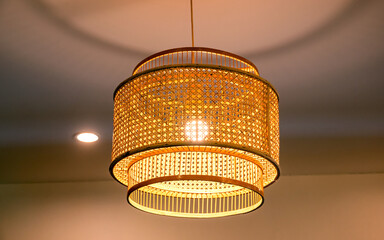 Warm bamboo pendant lamp hanging from ceiling. Cozy interior lighting with natural texture, perfect for home decor, lifestyle design, background, and modern interior concepts