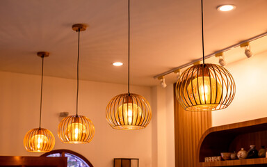 Warm pendant lights hanging from ceiling in cafe or restaurant interior. Cozy and elegant lighting design, perfect for interior decor, lifestyle concepts, and background use