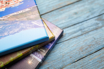 Stack of Photo Canvases with Wrapped Edges on Wooden Surface
