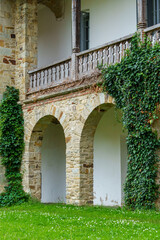 Naklejka premium close up of architectural details, old stone wall with arched opening and green ivy