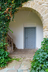 Naklejka premium close up of architectural details, old stone wall with arch and door