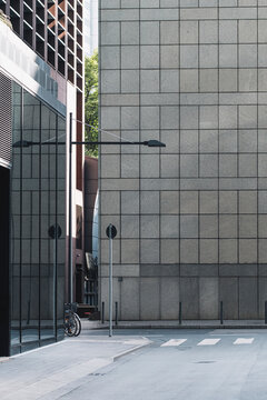 Empty urban passage corridor with tiled wall shadow lamp and pavement in a minimal composition creating quiet architectural background copy space