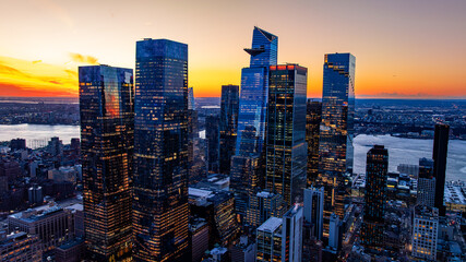 Obraz premium Hudson Yards skyscrapers at sunset. Aerial view of Hudson Yards towers reflecting sunset over the Hudson River
