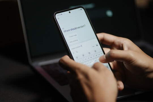 The hands of a man using a laptop or smartphone to operate artificial intelligence (AI), inputting commands and interacting with AI, AI assistants, chatbots, chatGPT.