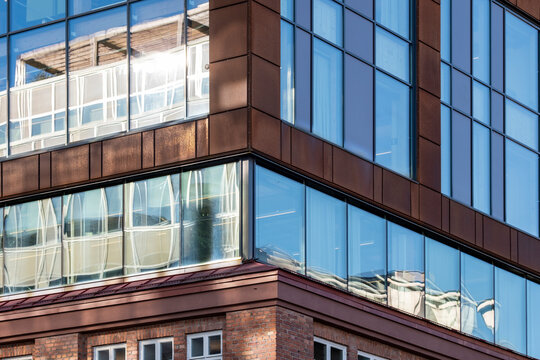 Modern urban architecture building corner facade with glass windows and brick reflection creating mixed material office exterior background
