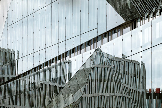 Modern architecture building facade with glass reflection and diagonal lines creating urban modern abstract office pattern background