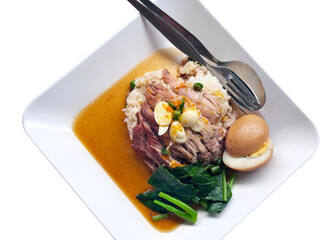 A top-down still of a plated Thai-style braised pork and rice dish