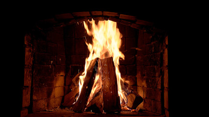 A blazing fire in a stone fireplace at home