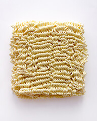 Uncooked Asian instant ramen noodles on a white background. Dried ramen noodles, uncooked Korean ramen noodles. Close-up of the noodles.