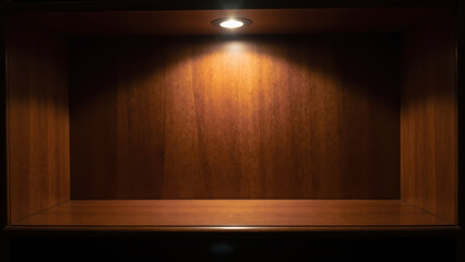 Empty wooden shelf illuminated by spotlight, showcasing warm, inviting atmosphere. Ideal for displaying items or decor