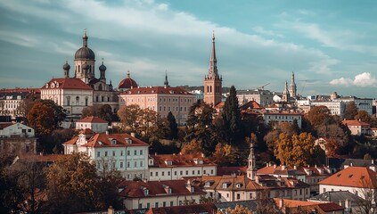 Obraz premium A picturesque cityscape with charming buildings under a cloudy sky. The architecture is a blend of styles, with domes and spires reaching towards the sky