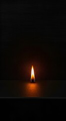 Single candle flame in darkness.