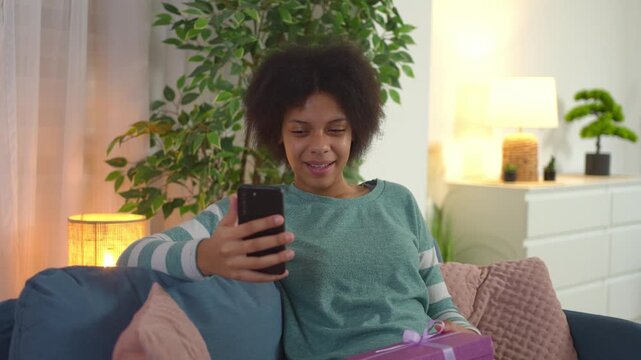 Happy young woman video calling and celebrating her birthday