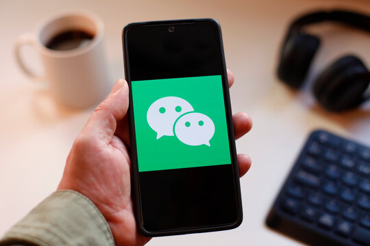 VALENCIA, SPAIN &ndash; 01-27, 2026: Person Holding Smartphone With WeChat APP Logo On Screen For Messaging App Concept