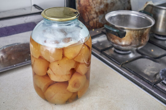 Moldy fermented fruit in glass jar as food spoilage concept