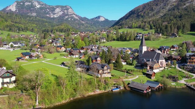 Aerial view of Altausseer See and village surrounded by mountains reflecting in calm alpine waters. Austria, Salzkammergut. Nature beauty in summer season
