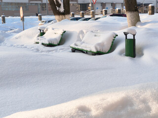 snow-covered bench . snow blockages. Benches in the city under the snow