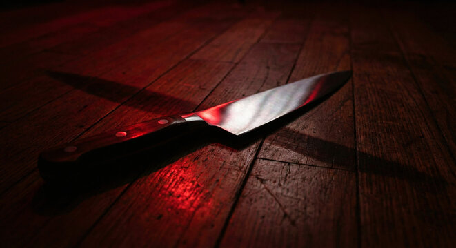 Sharp Kitchen Knife on Wooden Floor with Dramatic Red Light