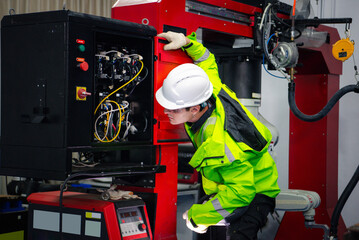 Machinery welding robots in production at factory industry, Robotic machine engineer is checking the operation of the robot arm manufacturing machine.