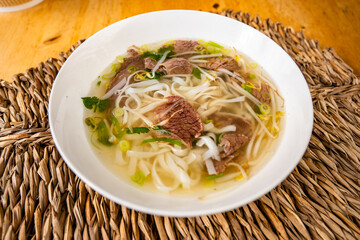 Vietnamese soup Pho bo in white bowl.
