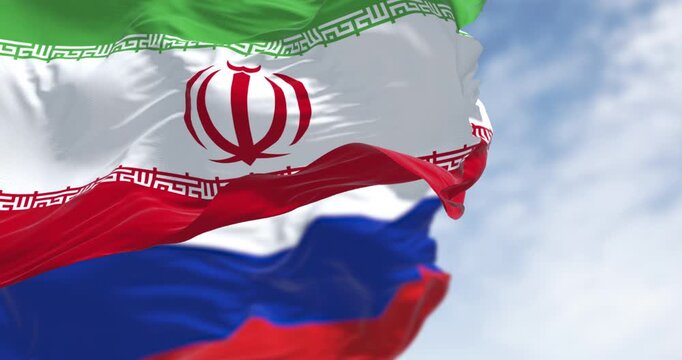 National flag of Iran and Russia waving in the wind on a clear day