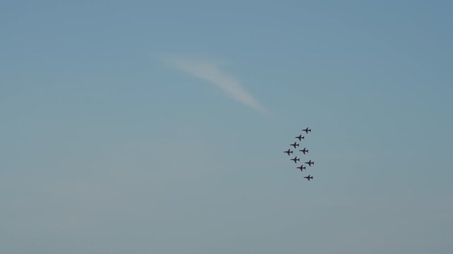 Video of an elite aerobatic jet team flying in formation, culminating in a spectacular display of red, white, and blue smoke trails against a clear blue sky. Perfect for patriotic events.